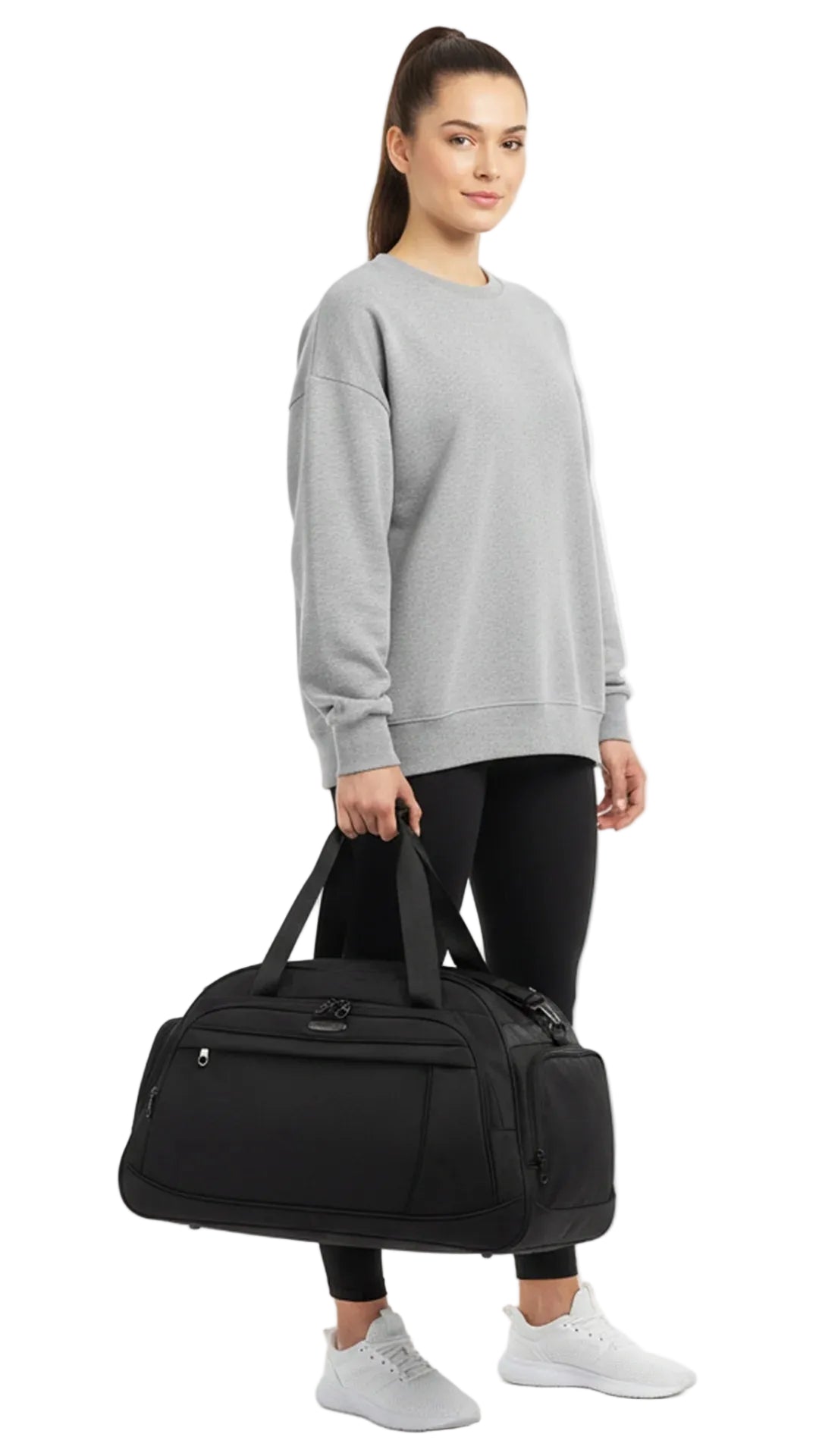 Woman holding a black duffel bag against a white background